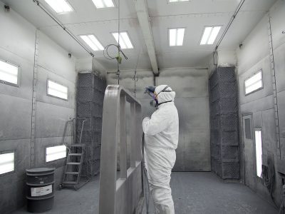 Painter in industrial paint booth
