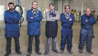 Ford technicians in front of paint booth